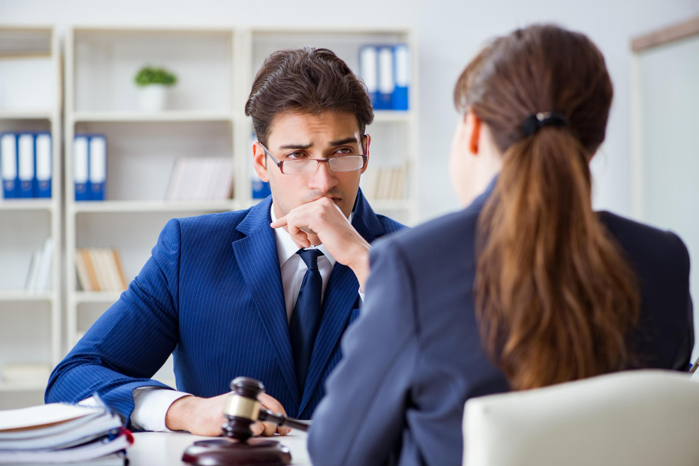 Attorney speaking with a client across an office desk