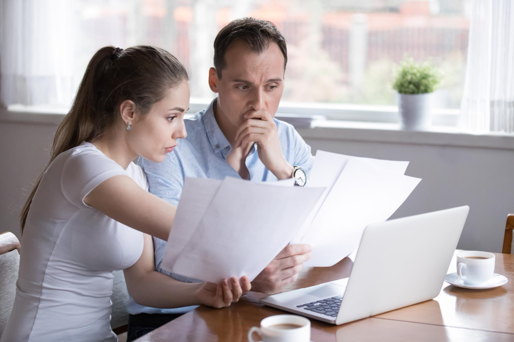 Couple reviewing bills and financial documents at home
